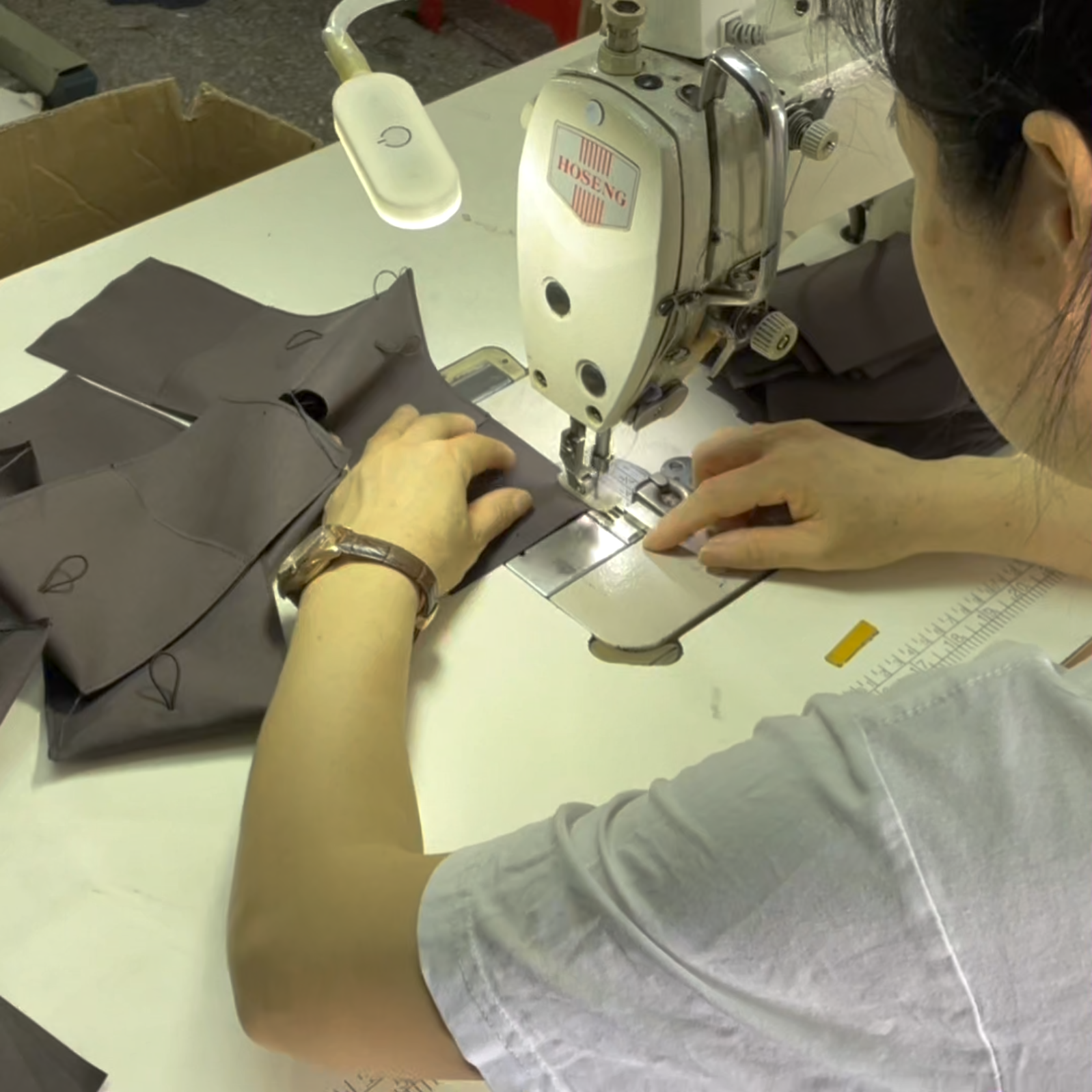 Sewing worker making custom drawstring bags - bag manufacturing